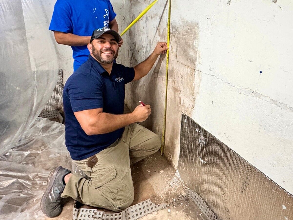 Masa bitumiczna do hydroizolacji Czarny pasta bitumiczna w otwartym wiadrze obok pędzla i wałka do aplikacji