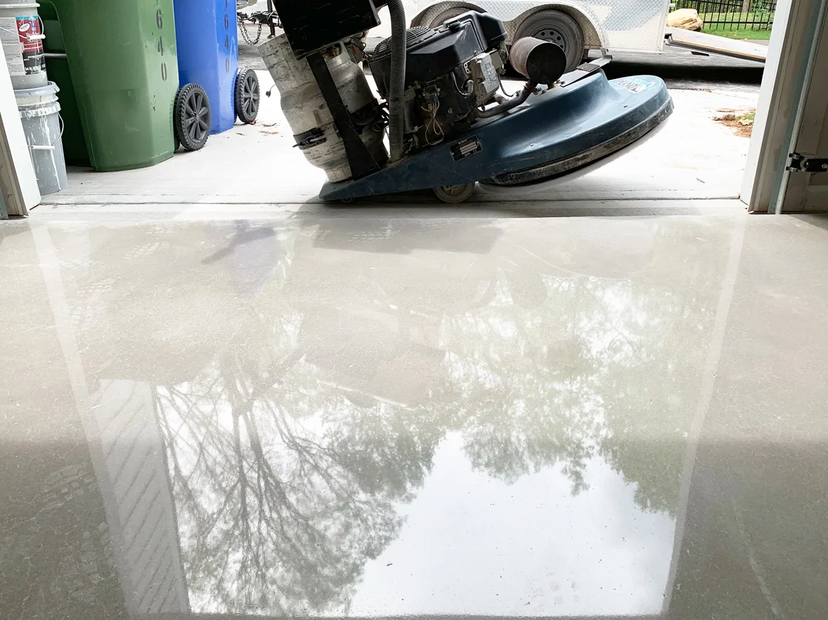 Butelka z przezroczystym impregnatem nano do betonu obok wałka malarskiego